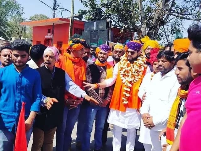खुले स्थान पर ध्वज के आसपास एकत्र प्रतिभागी।