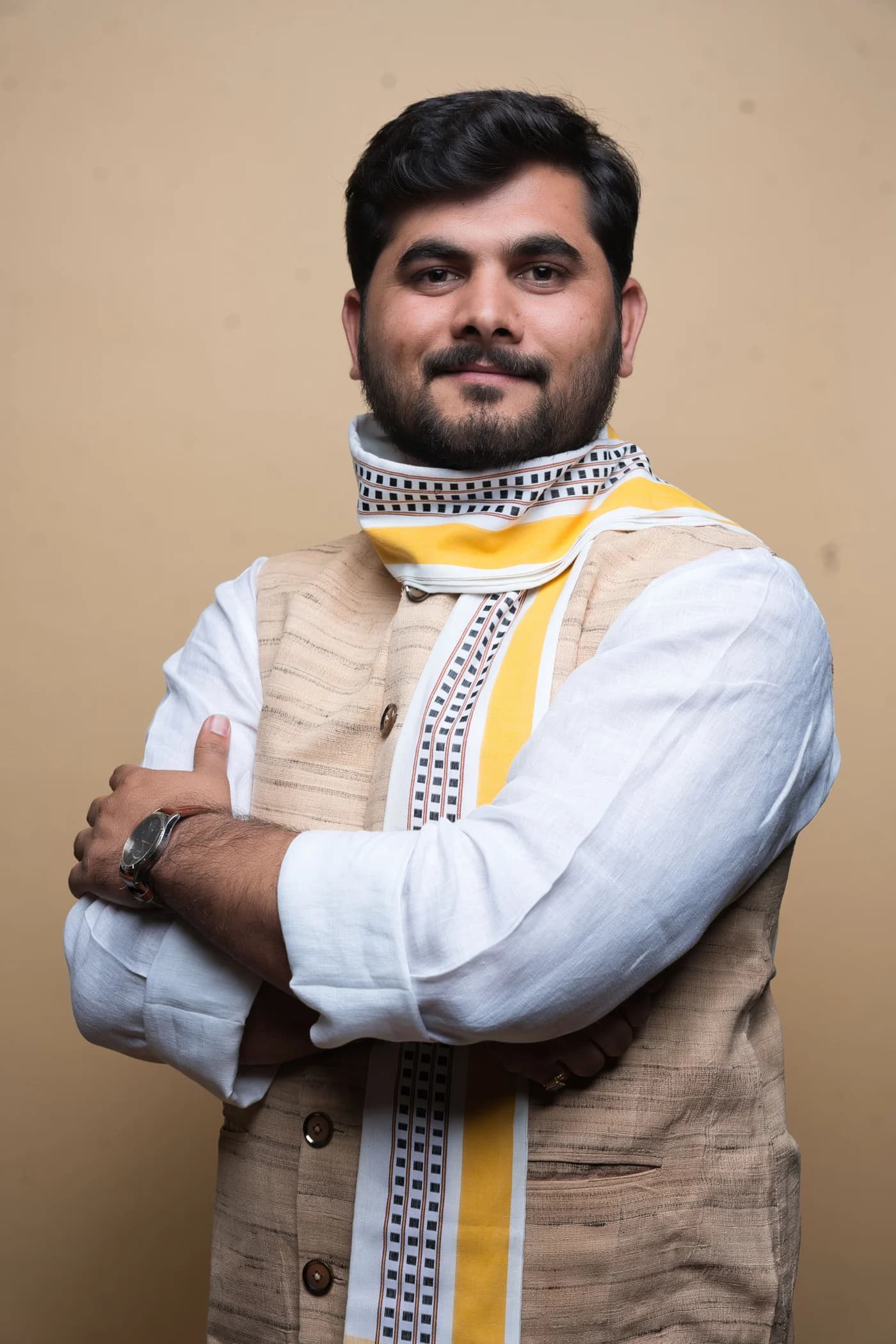 हल्की भूरी सदरी और डिज़ाइन वाले अंगवस्त्र में स्टूडियो चित्र।