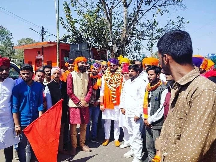 सामुदायिक कार्यक्रम में खुले स्थान पर साथ खड़ा समूह।