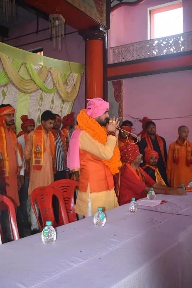 मंच पर माला पहने प्रतिभागी का स्वागत।