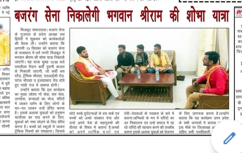 सामुदायिक बैठक में बैठे समूह को दिखाती उपलब्ध समाचार पत्र की कतरन।